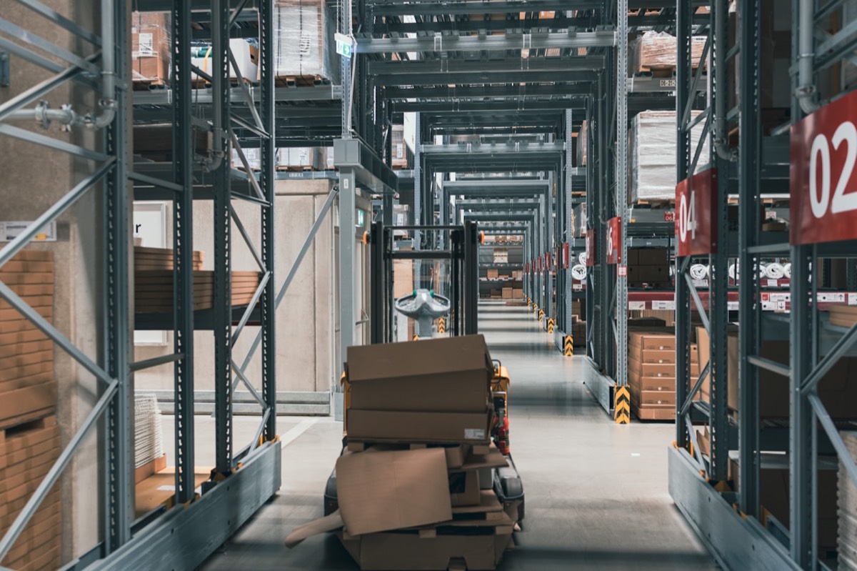 Warehouse aisle stacked with shipping boxes, representing D2C e-commerce fulfilment